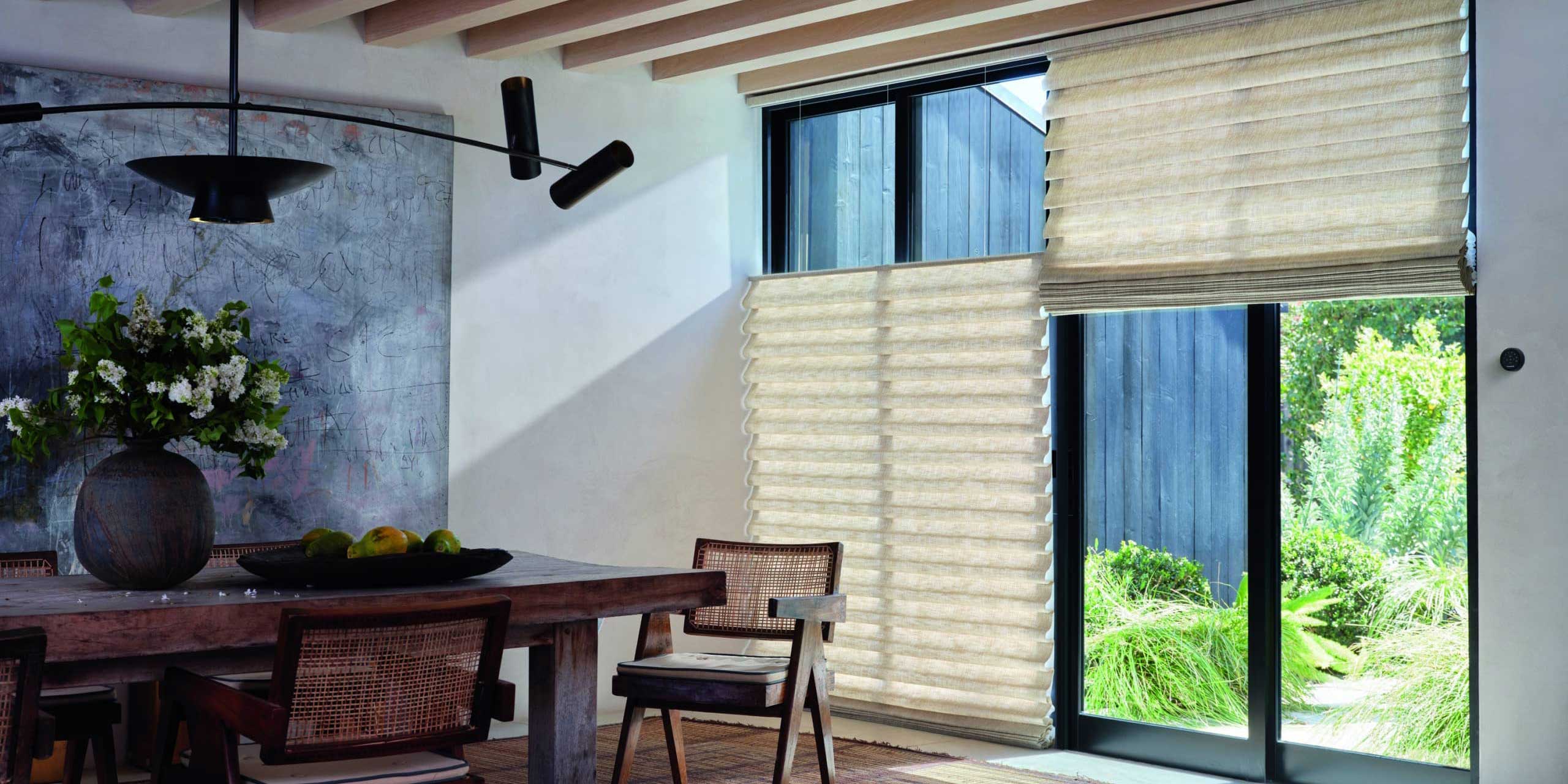 rustic and warm dining room with large doors and Hunter Douglas window treatments