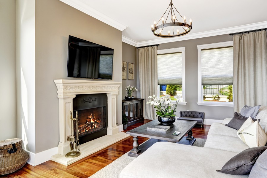 Living room showcasing a fireplace, television, and motorized shades.