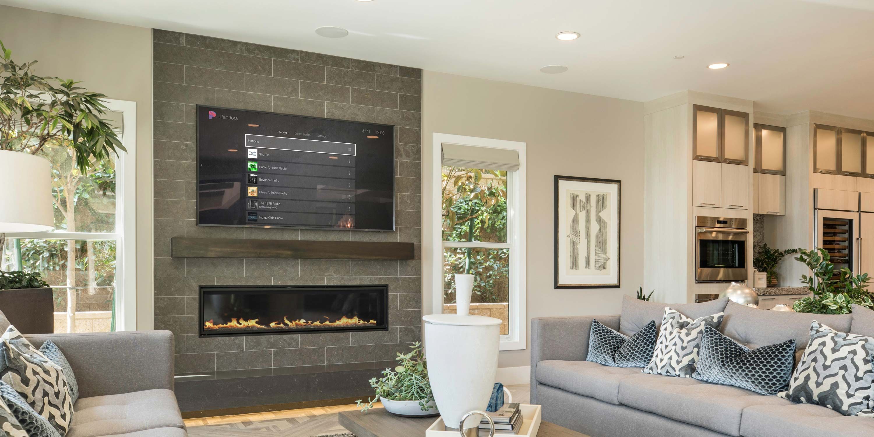 family room with a fireplace and tv with Control4 interface